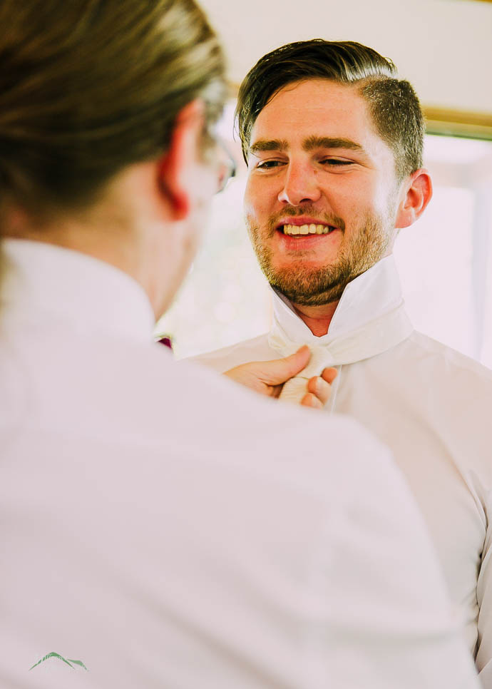 Groomsmen adjusting Groom’s tie
