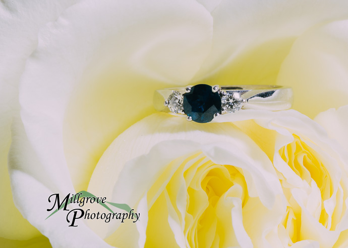 An engagement ring on a yellow flower.