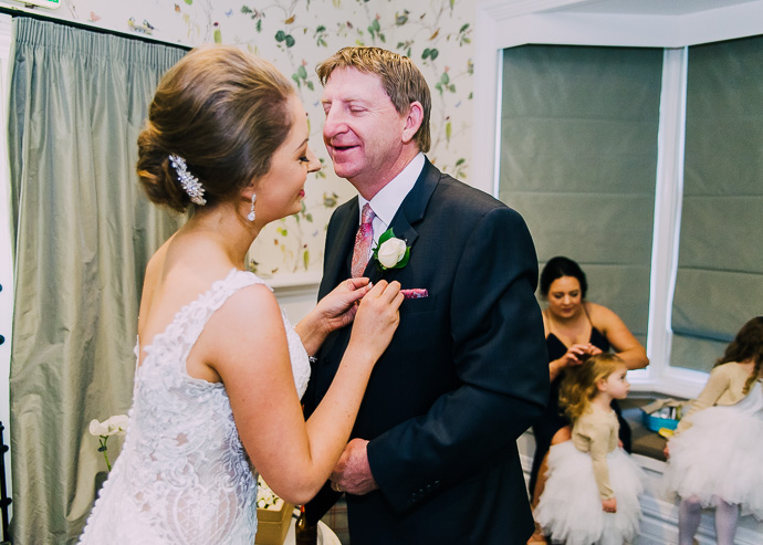 Bride pinning flower onto man