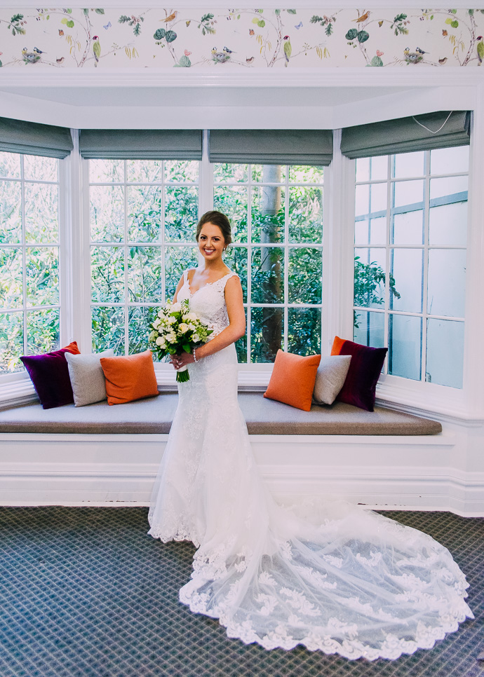 Bride standing next to a window