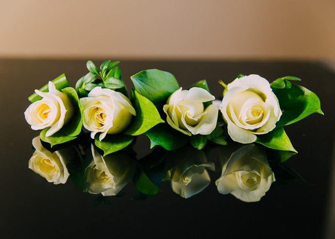 Four roses on a reflective table