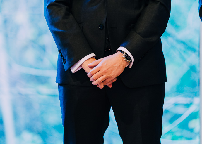 Groom clasping hands together