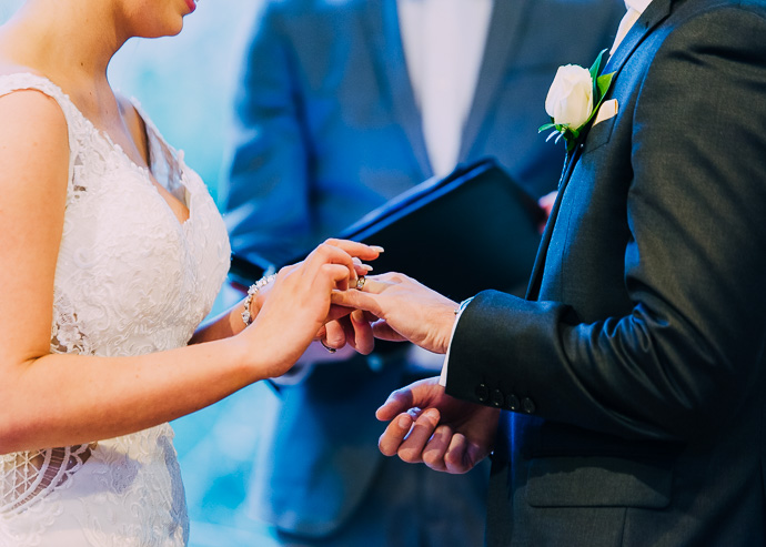 Bride placing ring on groom's finger