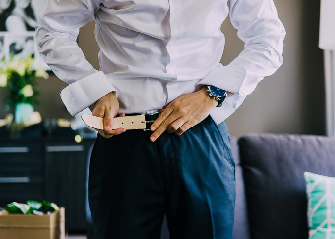 Groom doing up his belt