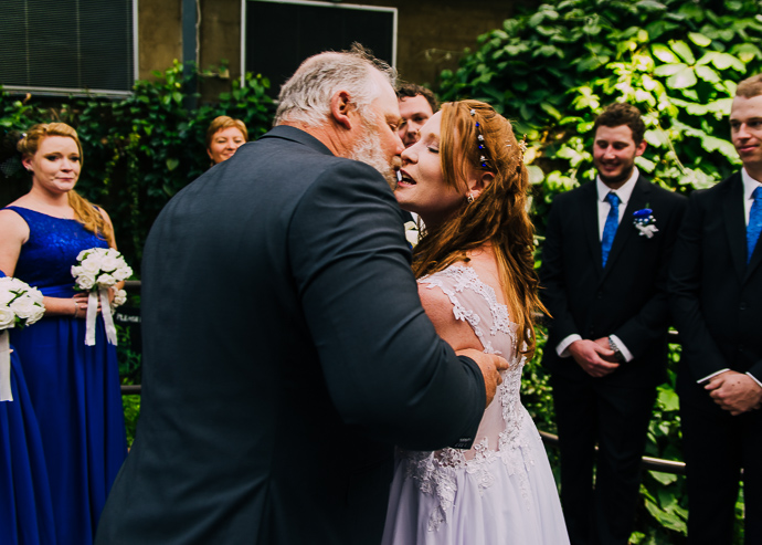 A bride kissing her father on the cheek