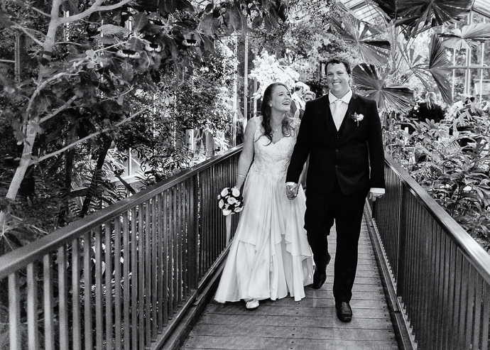 Bride and groom walking in Melbourne Zoo butterfly house