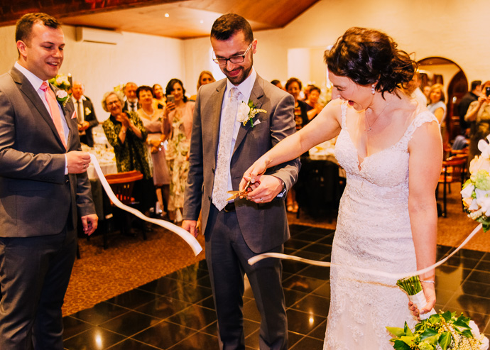 A bride and groom cutting a ribbon