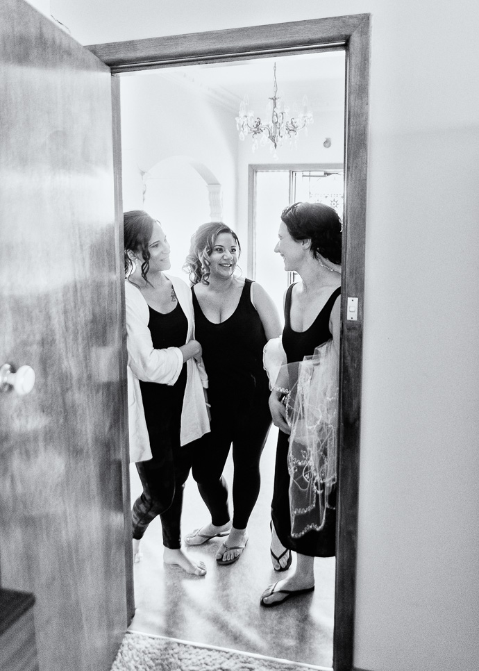 Three women standing in a doorway, black and white
