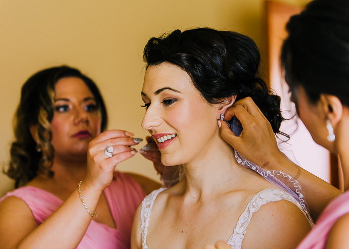Bridesmaids helping a bride with her jewellery