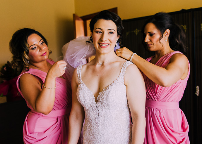 Bridesmaids helping a bride with her jewellery