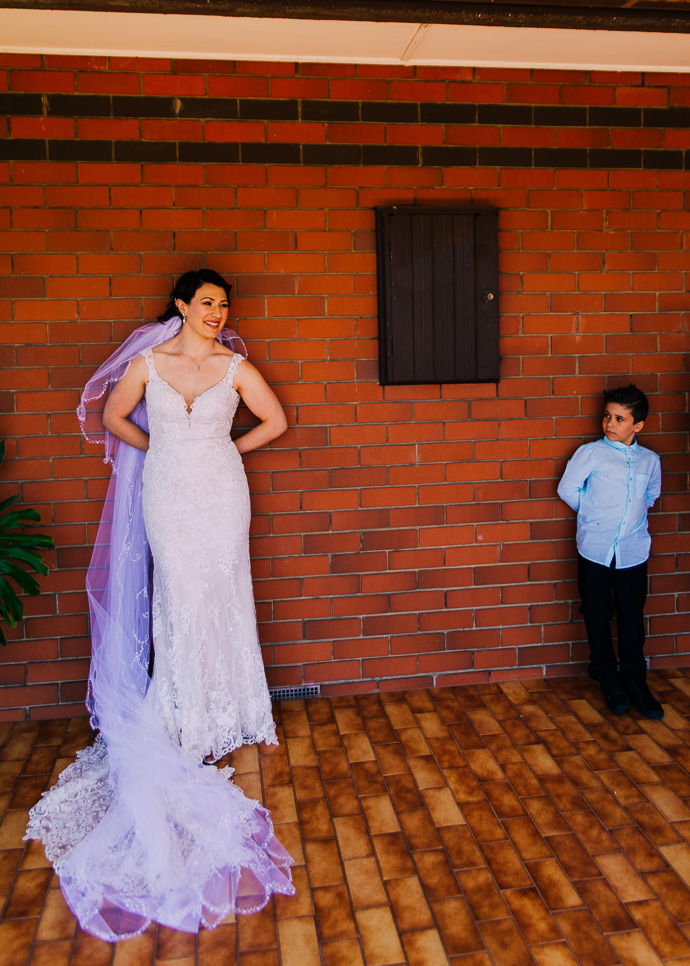 A bride and small boy standing in a similar pose