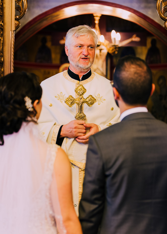 A priest between a bride and groom