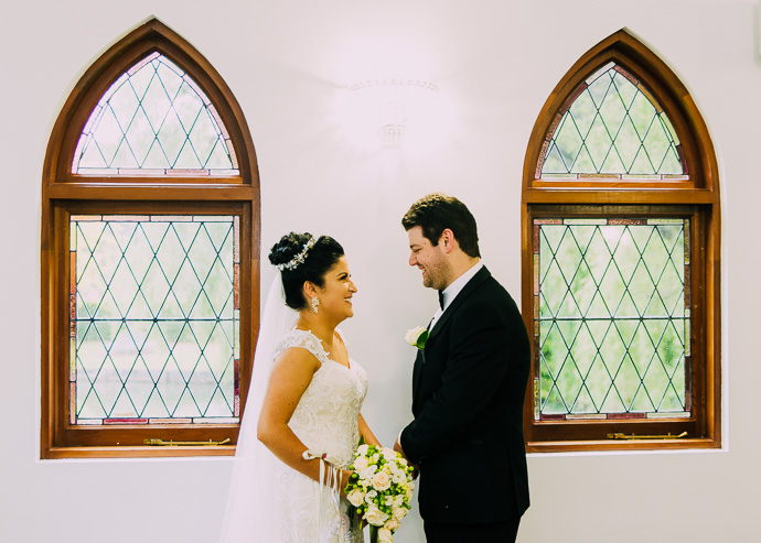 A bride and groom by a chapel window