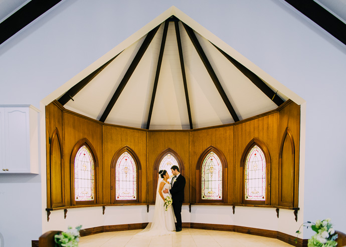A bride and groom standing in a chapel