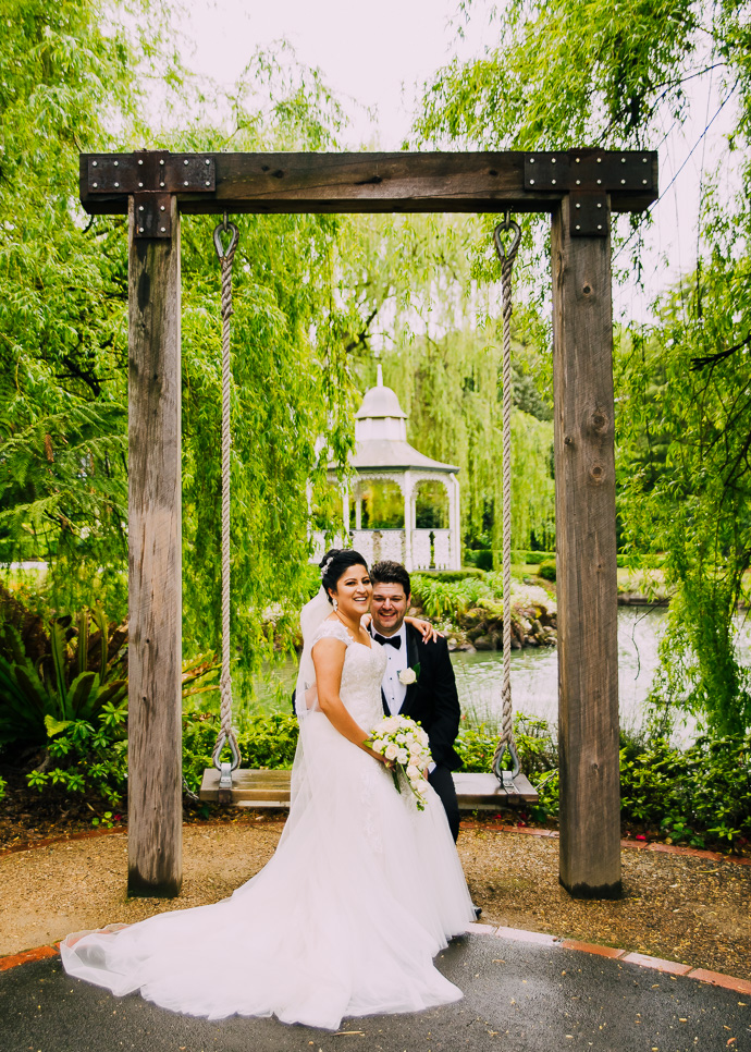 A bride and groom sitting on a swing