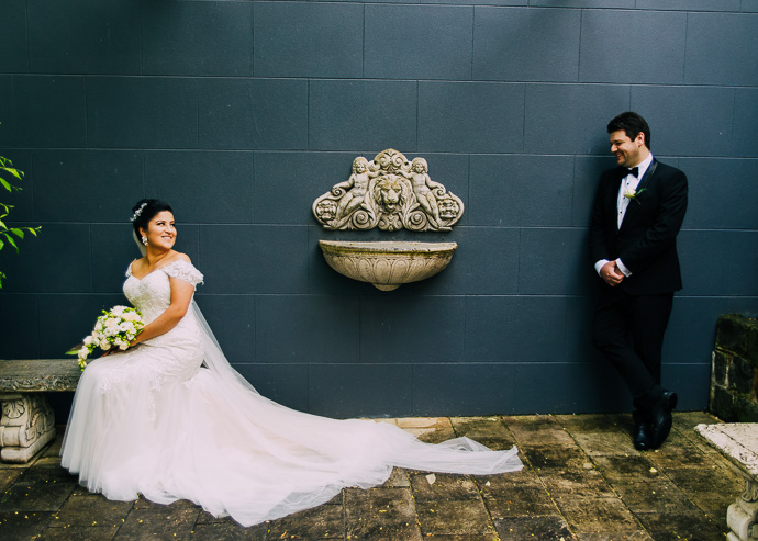 A bride and groom by a blue wall
