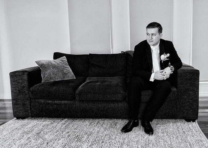 A man sitting on a couch, black and white