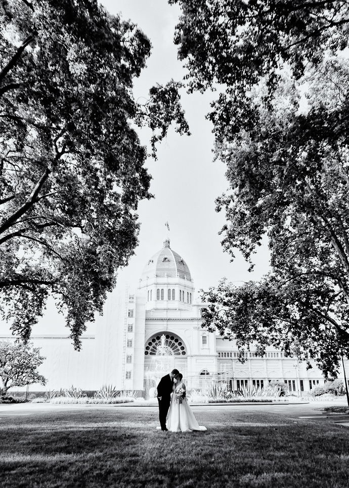 A bride and groom kissing in Carlton Gardens