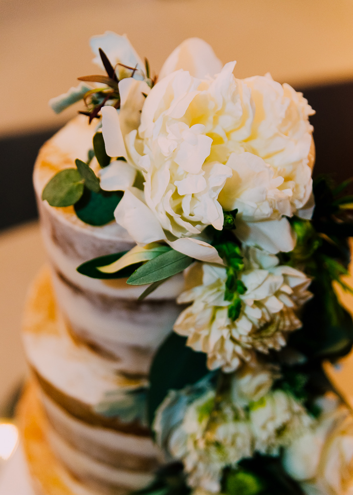 A wedding cake with a white rose