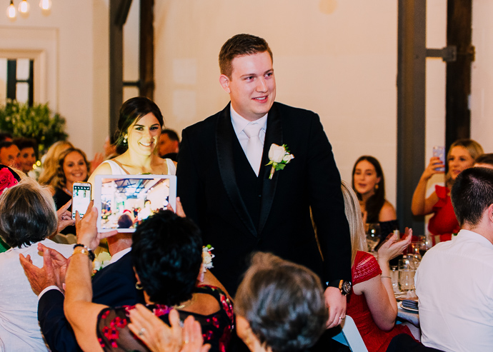 A bride and groom entering a wedding reception, iPad on display