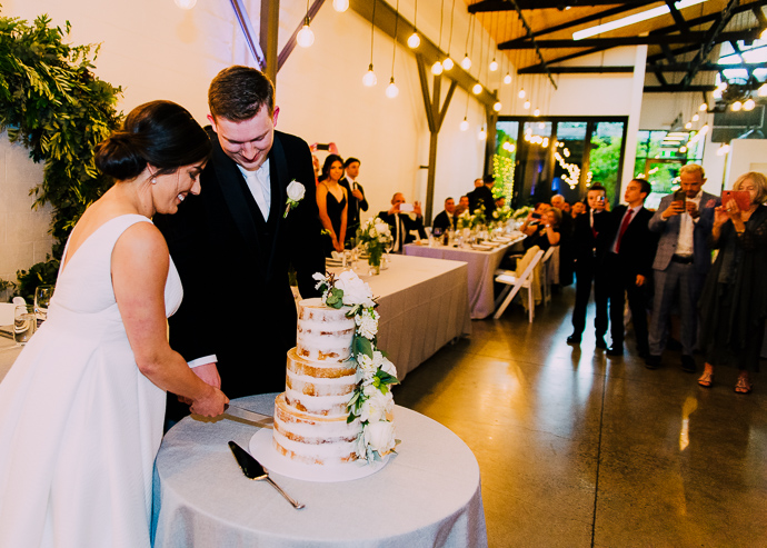 A bride and groom cutting their wedding cake