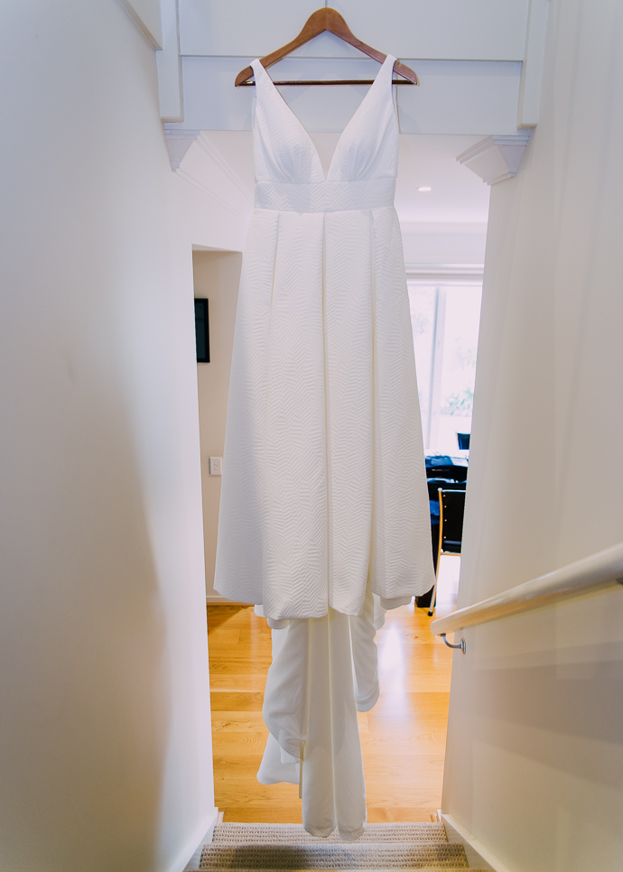 A wedding dress hanging in the window