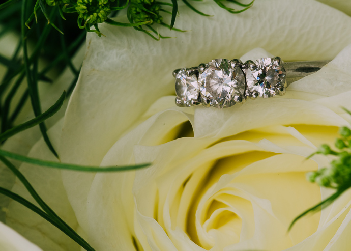 An engagement ring on a yellow flower.