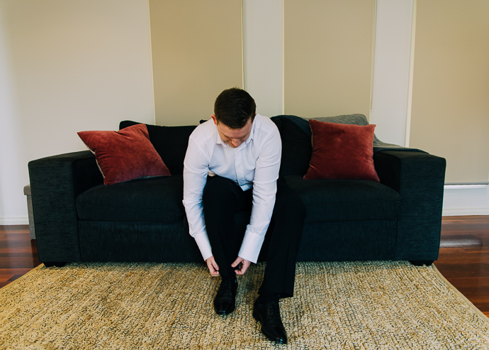 A groom putting on shoes