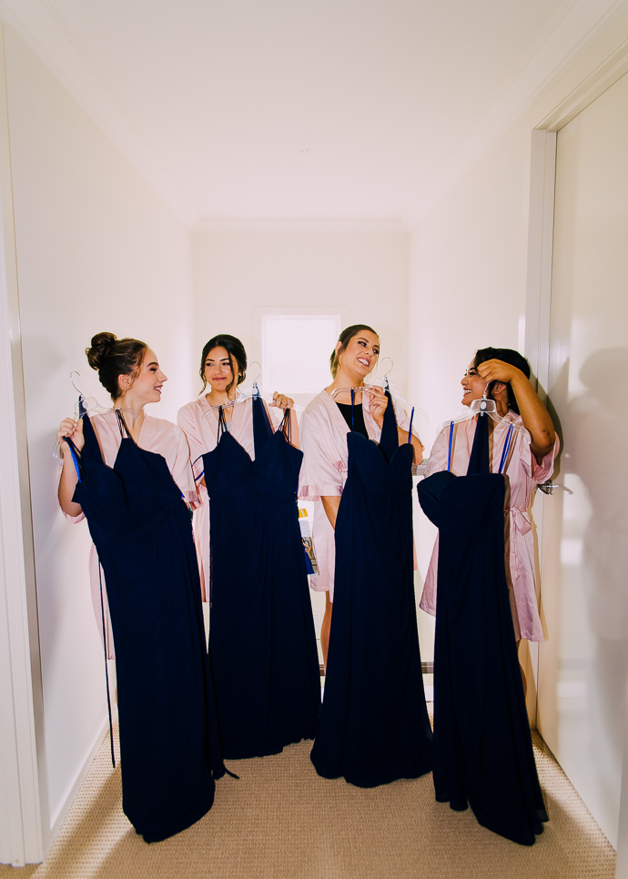 Bridesmaids holding their dresses