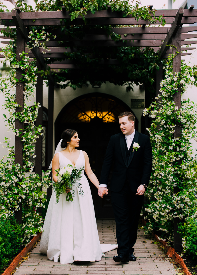 A bride and groom posing outside St Eustathios in South Melbourne