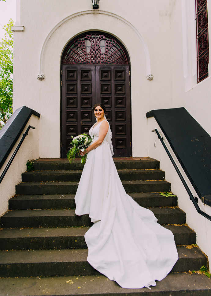 A bride and groom posing outside St Eustathios in South Melbourne