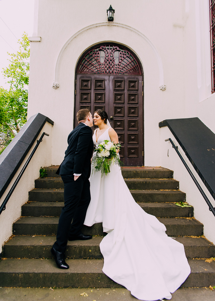 A bride and groom posing outside St Eustathios in South Melbourne