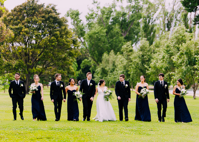 A bride and groom walking next to Albert Park Lake, near Carousel in St Kilda