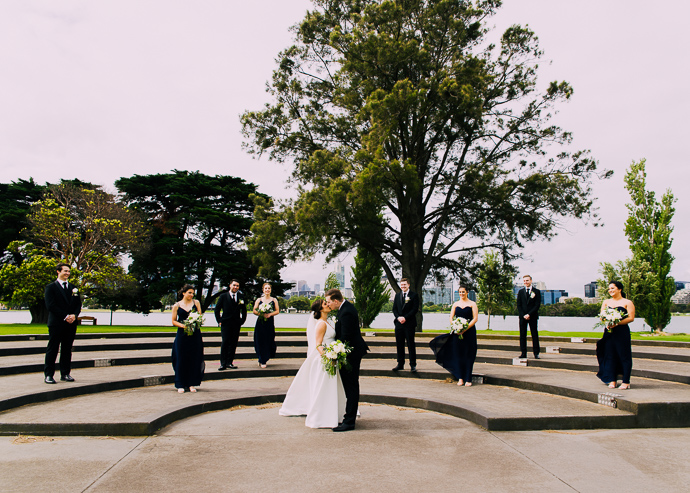 A bride and groom walking next to Albert Park Lake, near Carousel in St Kilda