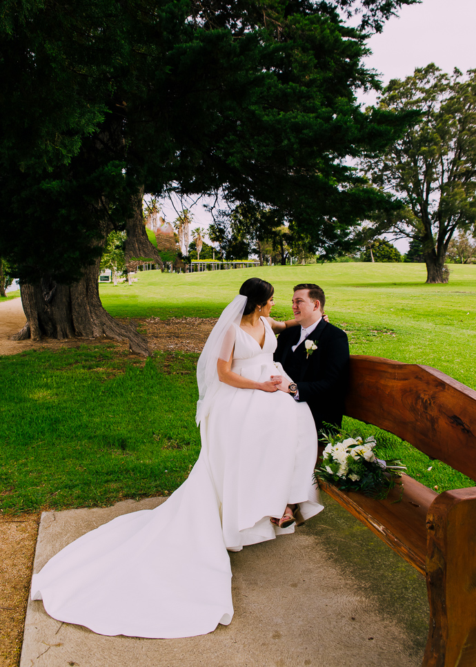 A bride and groom walking next to Albert Park LAke, near Carousel in St Kilda